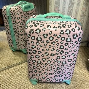 Cheetah print hardshell pink carry-on suitcase.